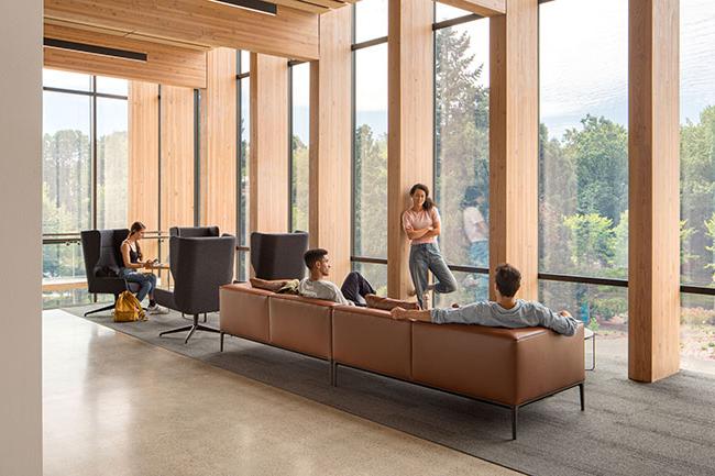 row of armchairs next to floor to ceiling windows alternating with wood paneling