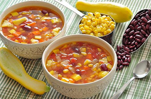 2 bowls of soup next to 2 scoops of beans